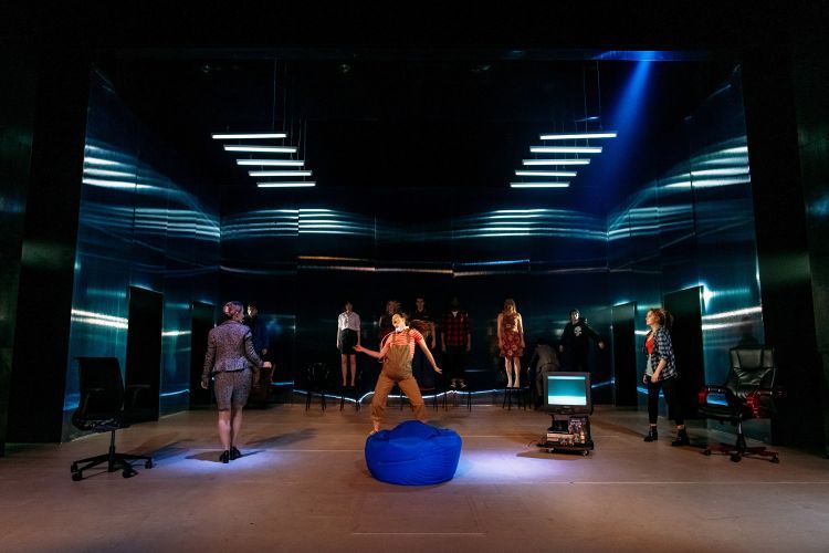 Actor dances on stage in Earthquakes in London under low lighting